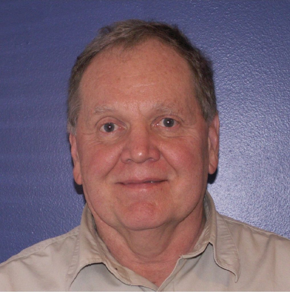 Man with gray hair, neutral expression.