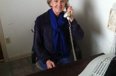 Woman talking on a telephone at desk.