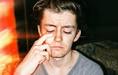 Person with tousled hair, thoughtful pose.
