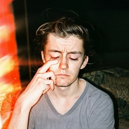 Person with tousled hair, thoughtful pose.