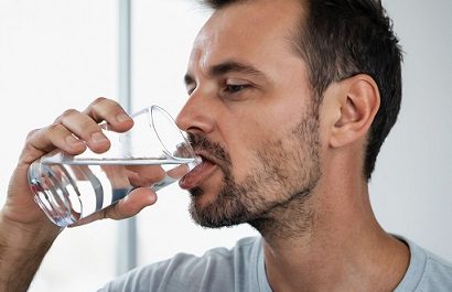 Person drinking water from glass