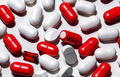 Red and white capsules scattered together